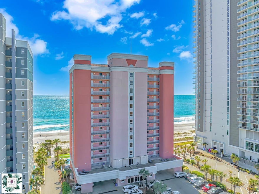 View of apartment building / complex featuring view of water and beach