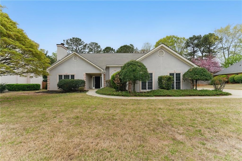Single story home with a front yard, stucco siding