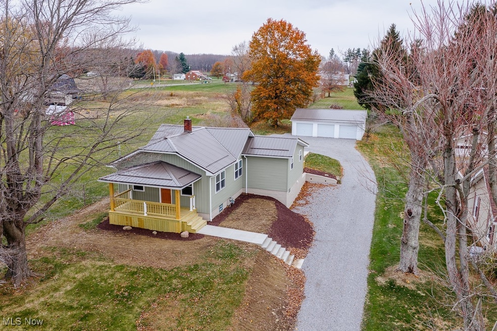 Bungalow-style house with a metal roof, covered porch, a standing seam roof, and a front yard