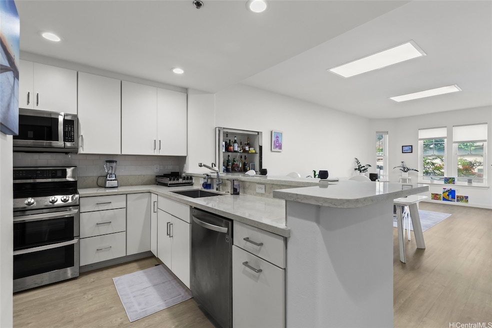 Totally renovated kitchen with stainless steel appliances, quartz countertops and white cabinets.