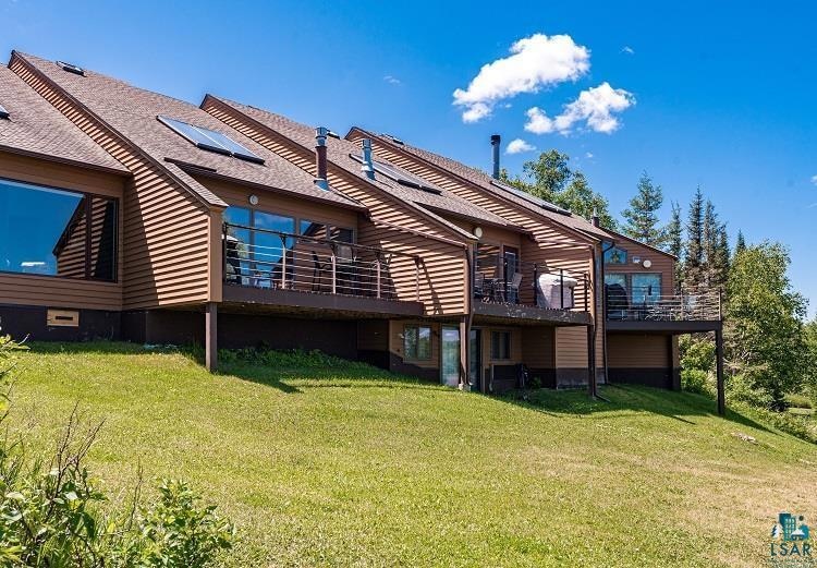 Rear view of property featuring roof mounted solar