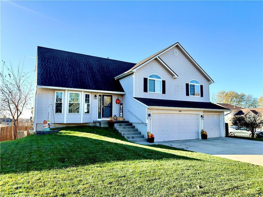 Split level home featuring an attached garage, concrete driveway, and a shingled roof