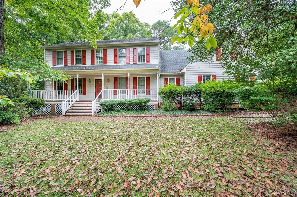 Colonial home with a porch and a front yard