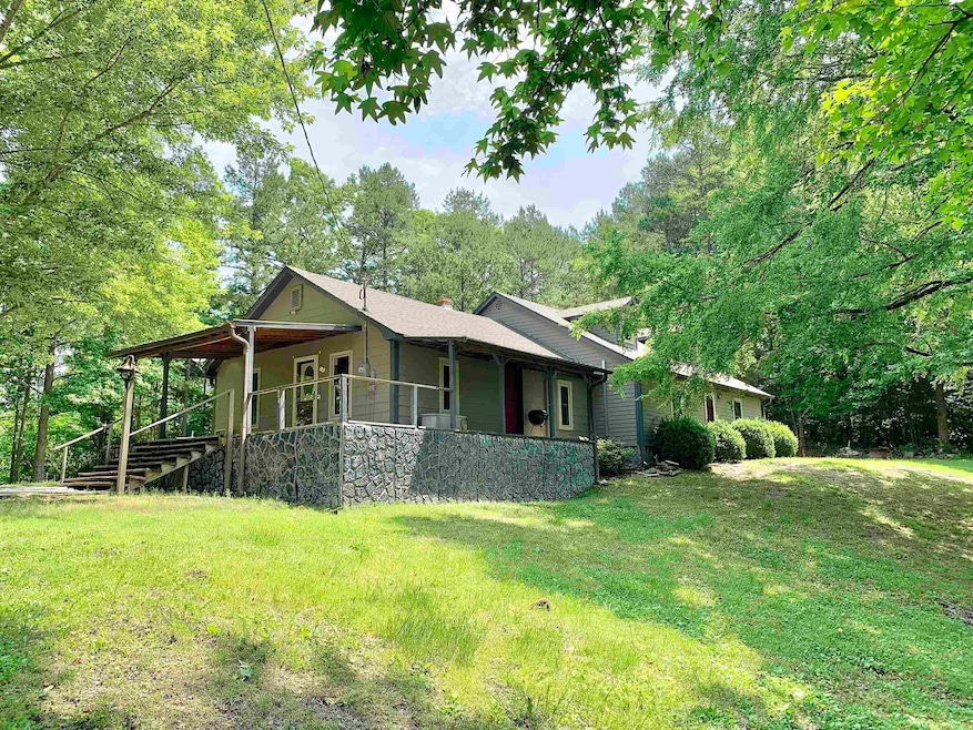 View of front of home with a front yard, covered porch, and a chimney