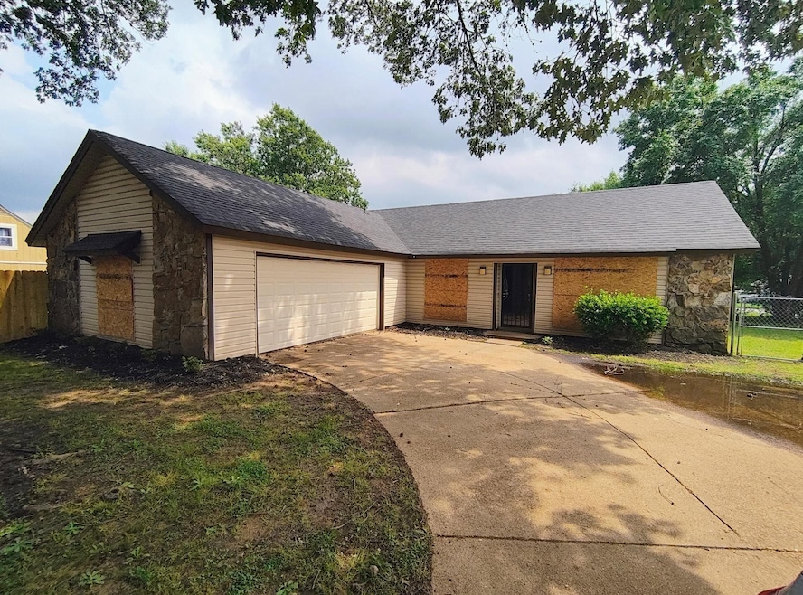 View of front of home featuring stone siding, a garage, concrete driveway, and roof with shingles
