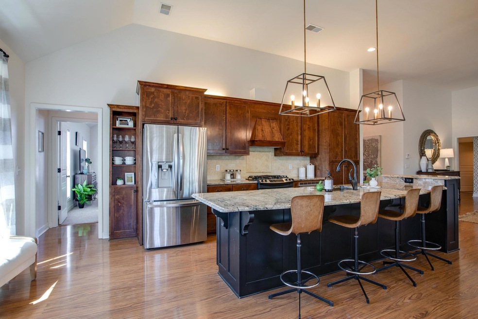This Custom Kitchen Offers a Huge Kitchen Island with Granite Countertop and Plenty of Bar Seating! Also Featured are Open Pendant Lights, Stainless Steel Appliances, Built in Bookshelves, and Up Lighting! Watch Your Favorite Chef Cook for You!!