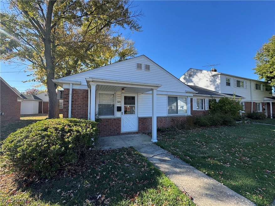 Ranch-style house with brick siding, a front lawn, and a porch