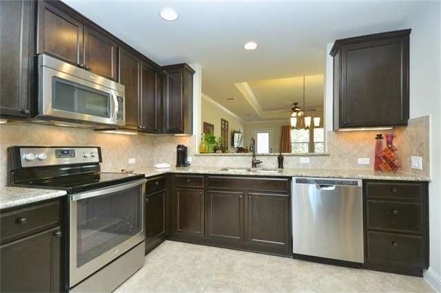Gleaming stainless steel appliances and gorgeous granite counter tops circle the magical Open Kitchen of this delightful Sun City Texas Gray Myst.