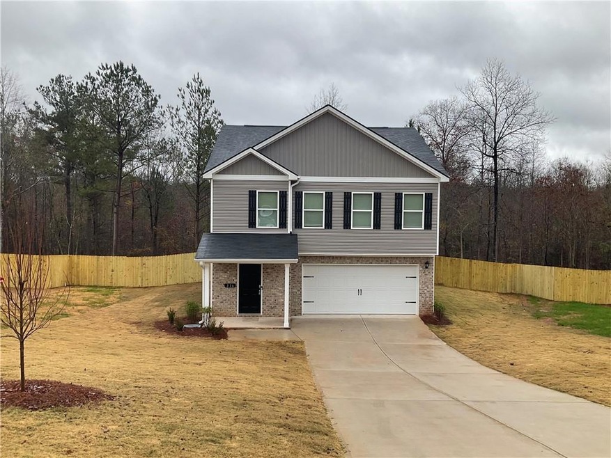View of front of property featuring a front yard and a garage