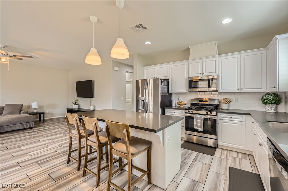 Kitchen with open floor plan, visible vents, dark