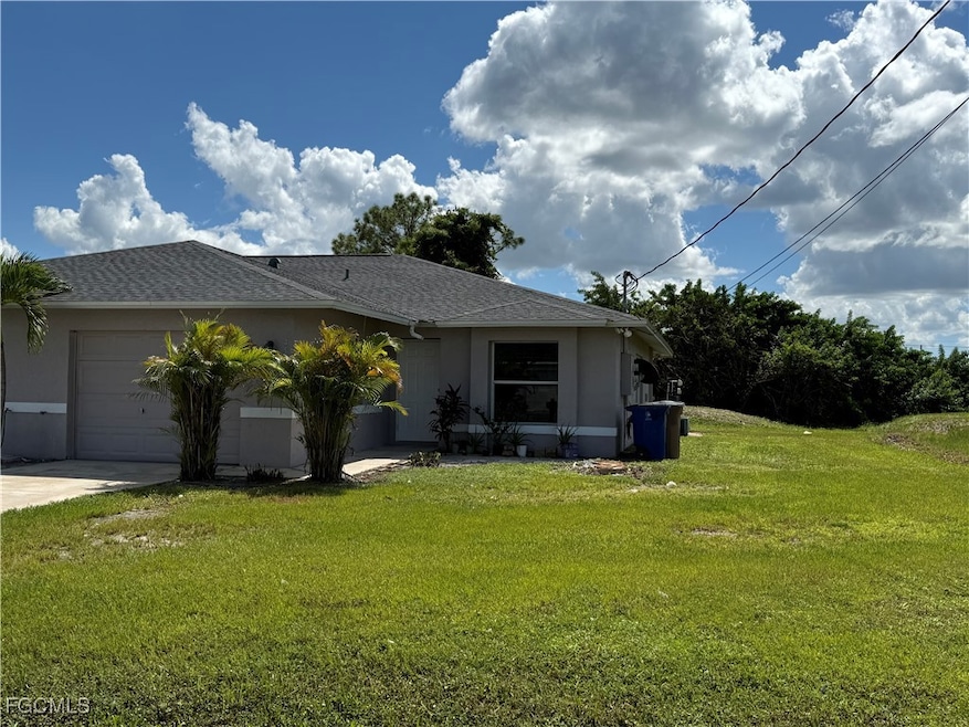 View of front of property featuring a front lawn, stucco siding, a garage, and roof with shingles