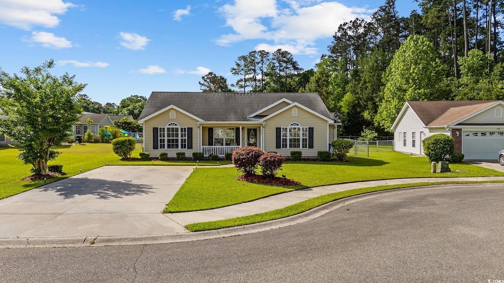 Single story home featuring a porch, fence, driveway, and a front yard
