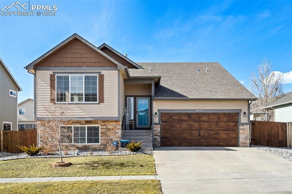 View of front of home with a front lawn and a gara