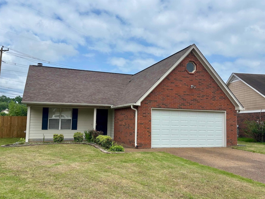 View of front of home with asphalt driveway, a shingled roof, brick siding, and a garage