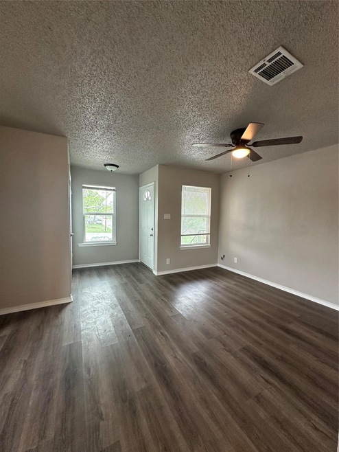 Unfurnished living room with dark wood finished f