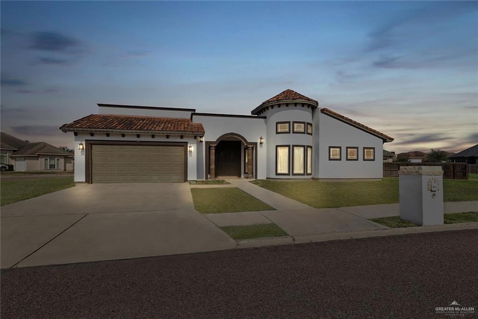 Mediterranean / spanish-style home featuring a garage and a lawn
