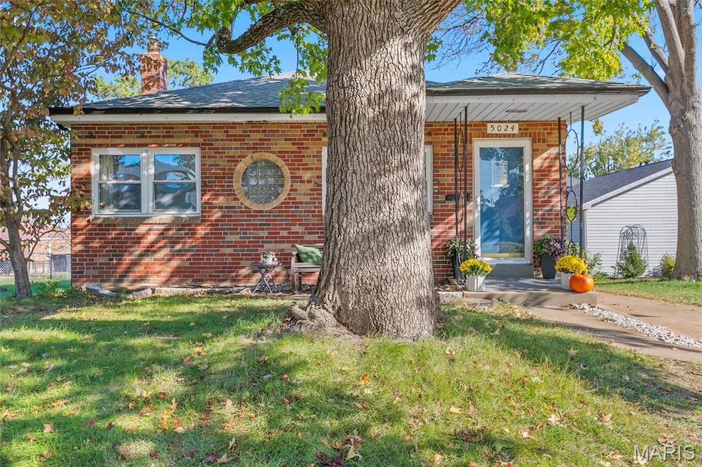 View of front of house with a front lawn, brick siding, and a chimney