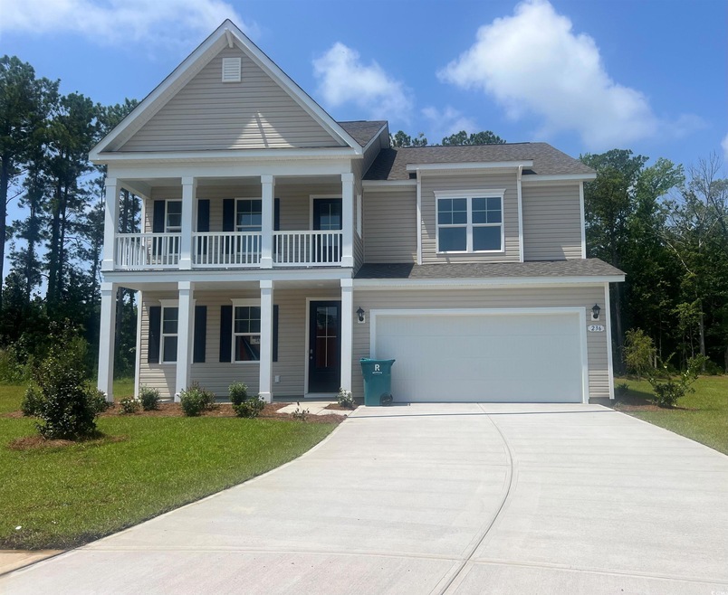 View of front of property featuring a balcony, a g