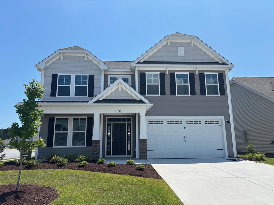 Craftsman-style house featuring an attached garage, driveway, a front yard, and brick siding