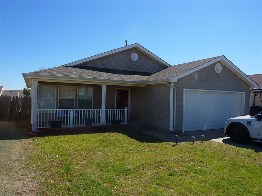 Ranch-style home with covered porch, a garage, and