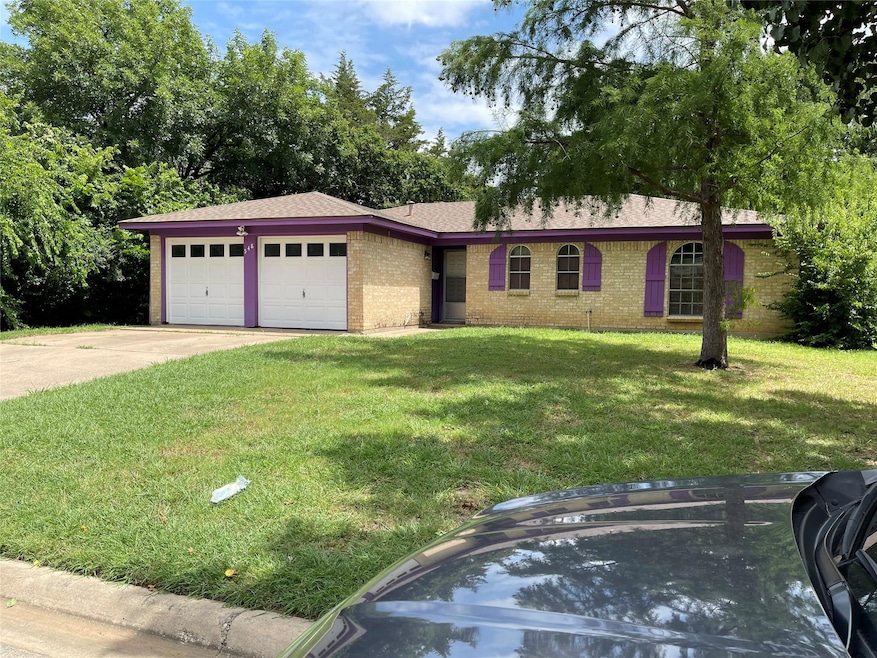 Ranch-style house with a garage and a front lawn