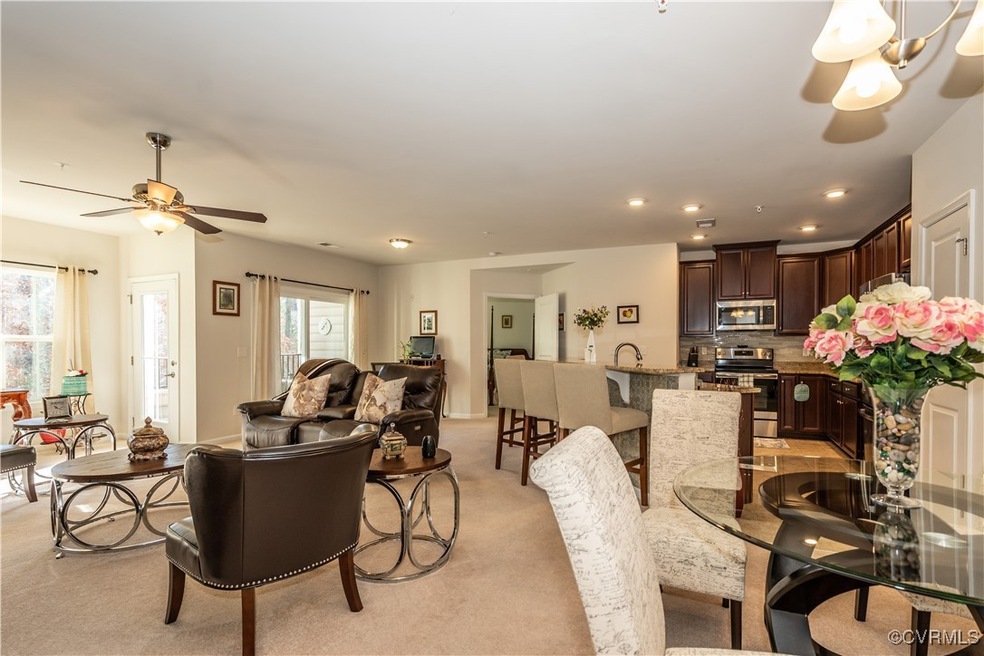 Carpeted living room featuring ceiling fan and sin