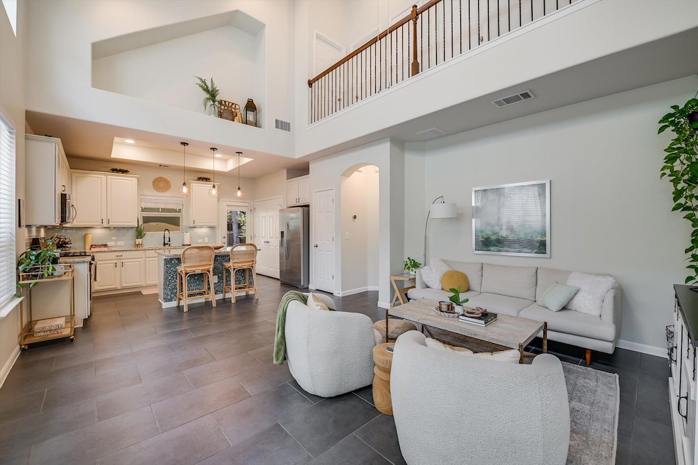 Living room featuring arched walkways, a high cei