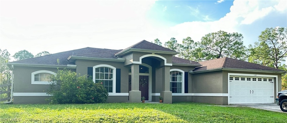View of front of home with a front lawn and a gara