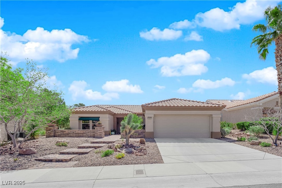 View of front of home with a garage, driveway, stu