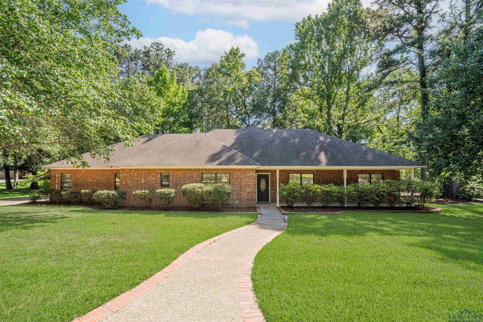 Ranch-style home with a front yard, brick siding, and roof with shingles