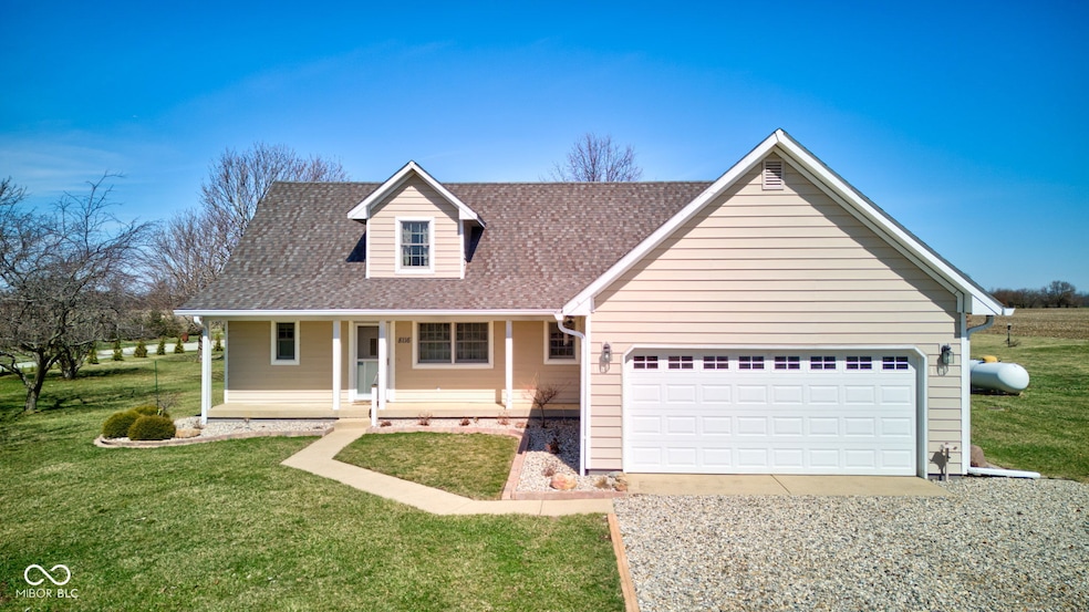 view of front of house with a garage, a porch, a front lawn, and a shingled roof