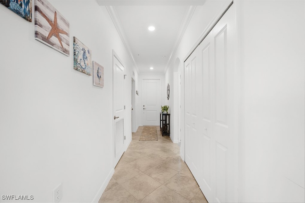 Hallway featuring ornamental molding, recessed lighting, and light tile patterned floors