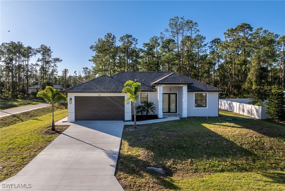 View of front of home with a front lawn and a gara