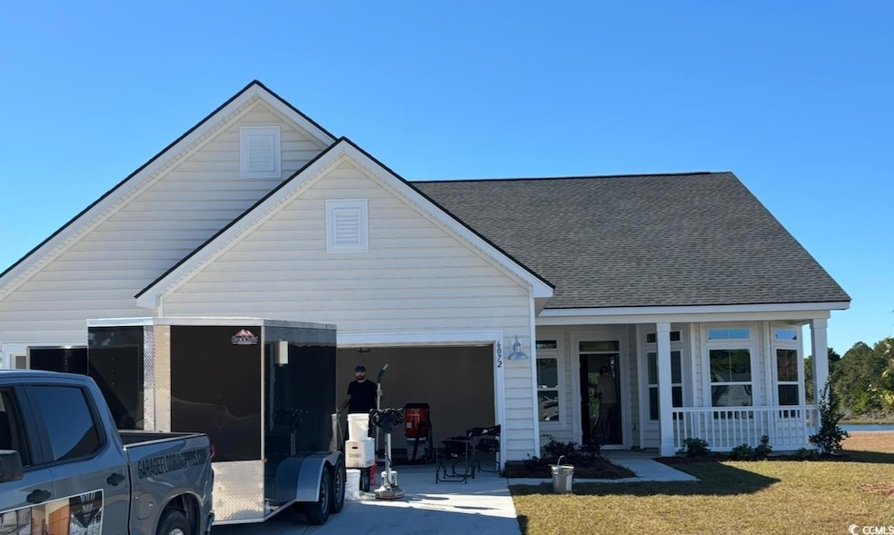 View of front of house with roof with shingles, a porch, concrete driveway, and a front lawn