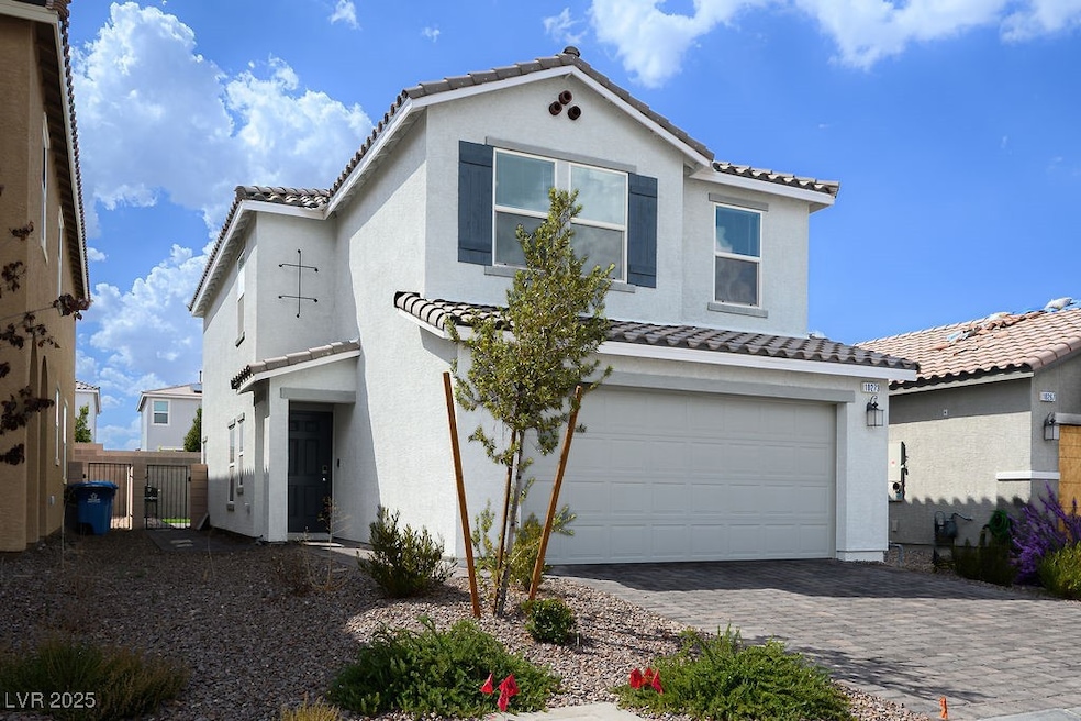 Mediterranean / spanish house with a tile roof, an attached garage, stucco siding, and driveway