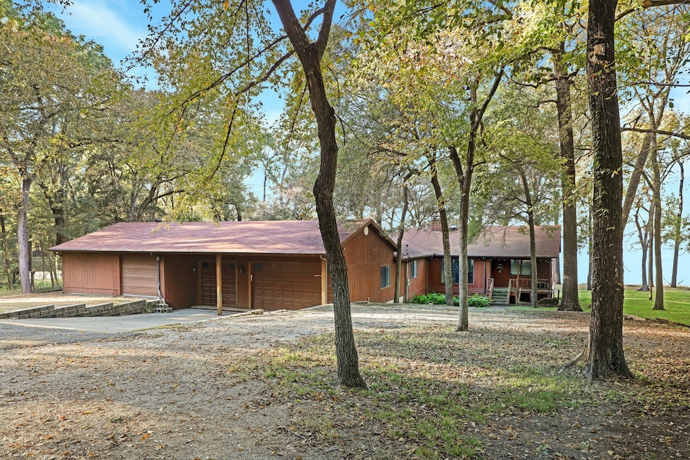 View of front facade with a shingled roof and driveway