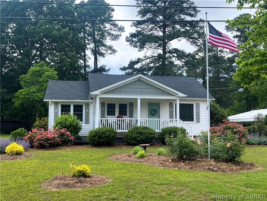View of front of home with a front lawn and a porc