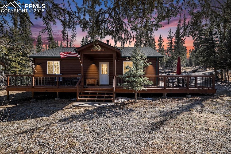 Chalet / cabin featuring a wooden deck, a shingled roof, and log veneer siding
