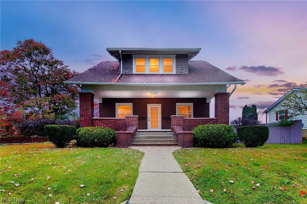 View of front of property with a yard and covered porch