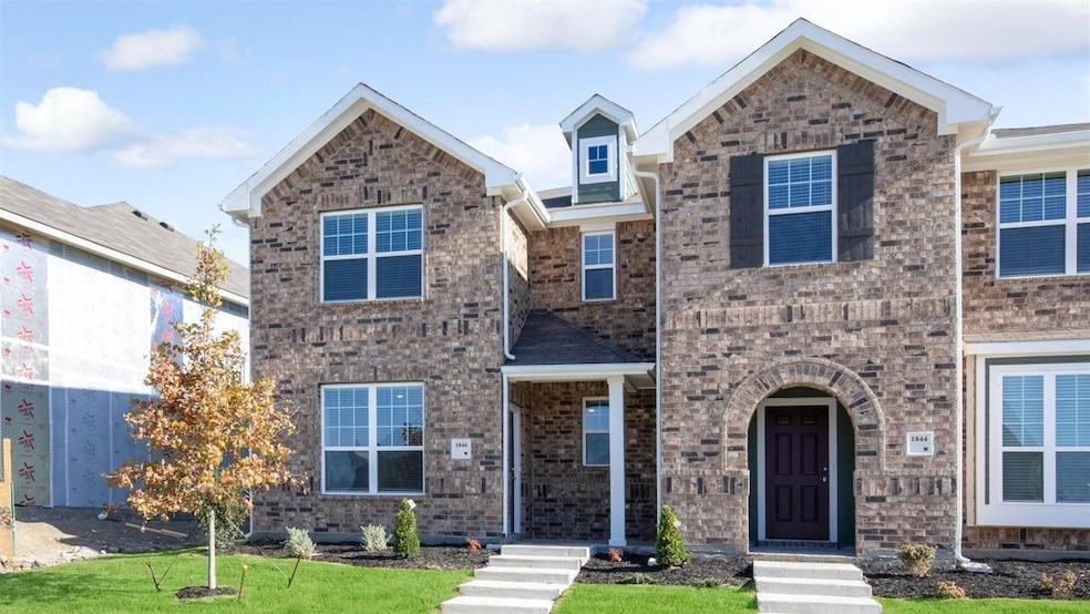 Traditional-style house with brick siding and a front lawn
