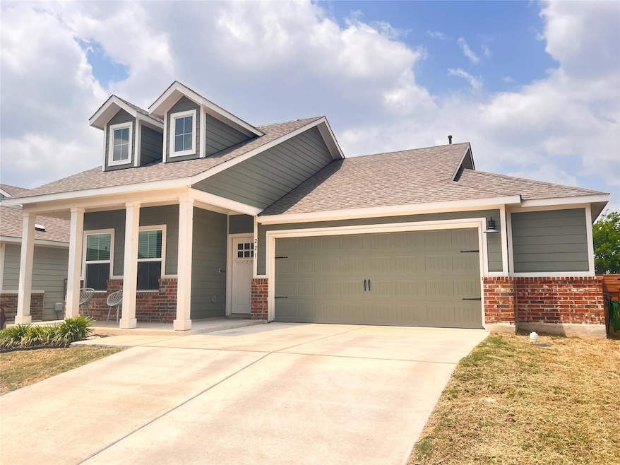 View of front of property with brick siding, a ga