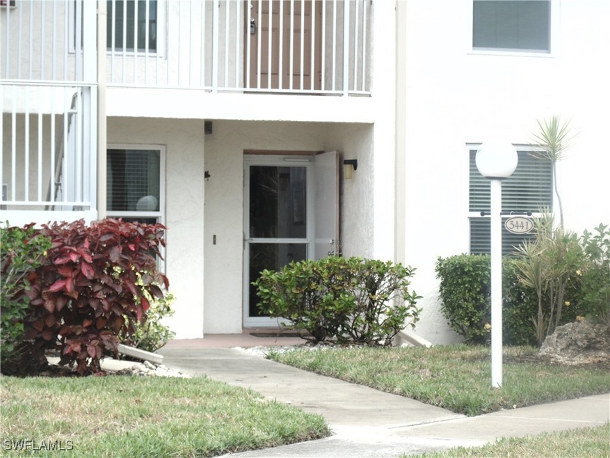 Property entrance featuring stucco siding and a ba