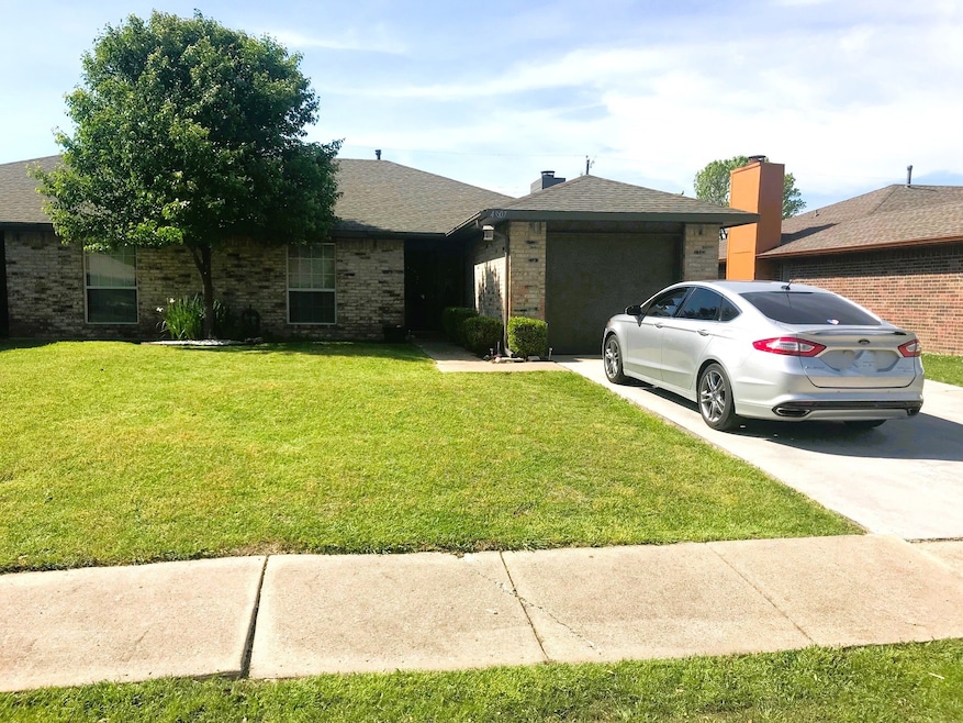 Single-story home with sidewalk, brick siding, concrete driveway, a garage