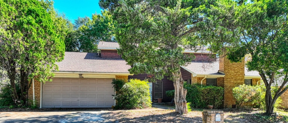 Obstructed view of property with roof with shingles, brick siding, driveway, and a garage