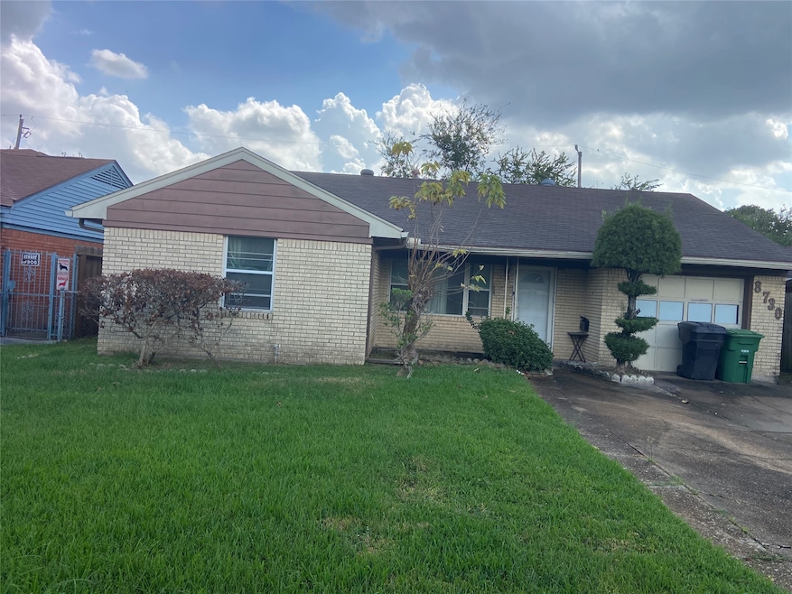 The front elevation provides a beautigul view of the yard, driveway and brick and aluminum siding construction of this Pleasantville home.