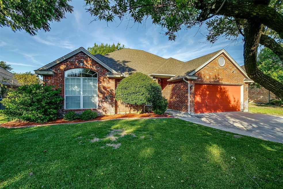 View of front of home featuring a front lawn and a garage