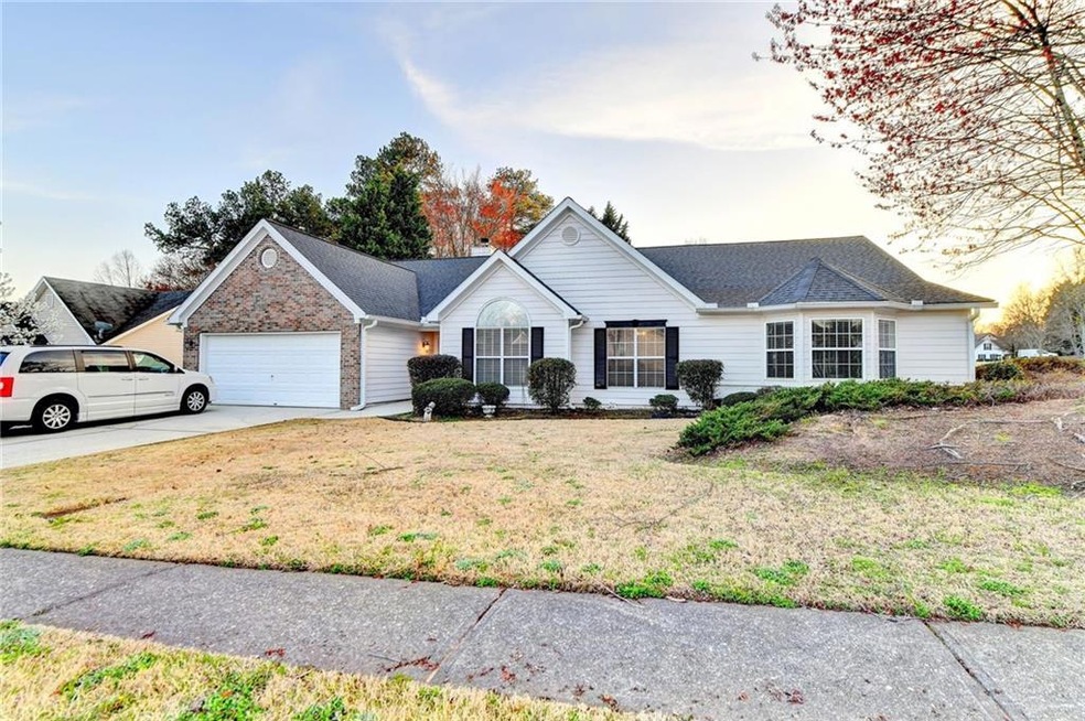 Single story home with a garage and a yard