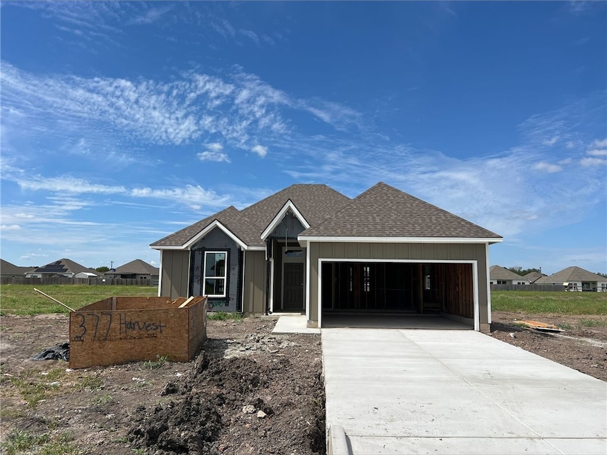 Unfinished property with a shingled roof, driveway, a garage, and board and batten siding