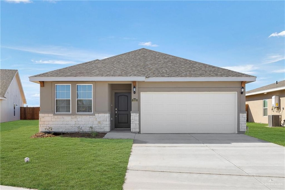 Ranch-style home with a garage, driveway, stone siding, roof with shingles, and a front yard