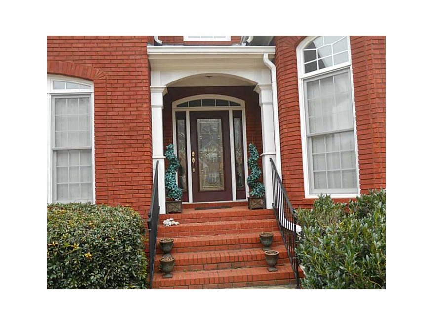 Exterior Front. Leaded glass doors make the entry 